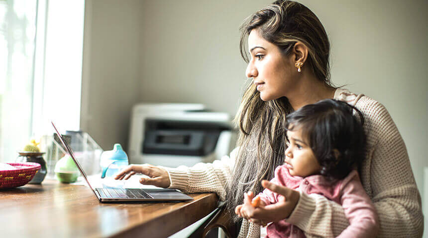 mother hold daughter looking at laptop