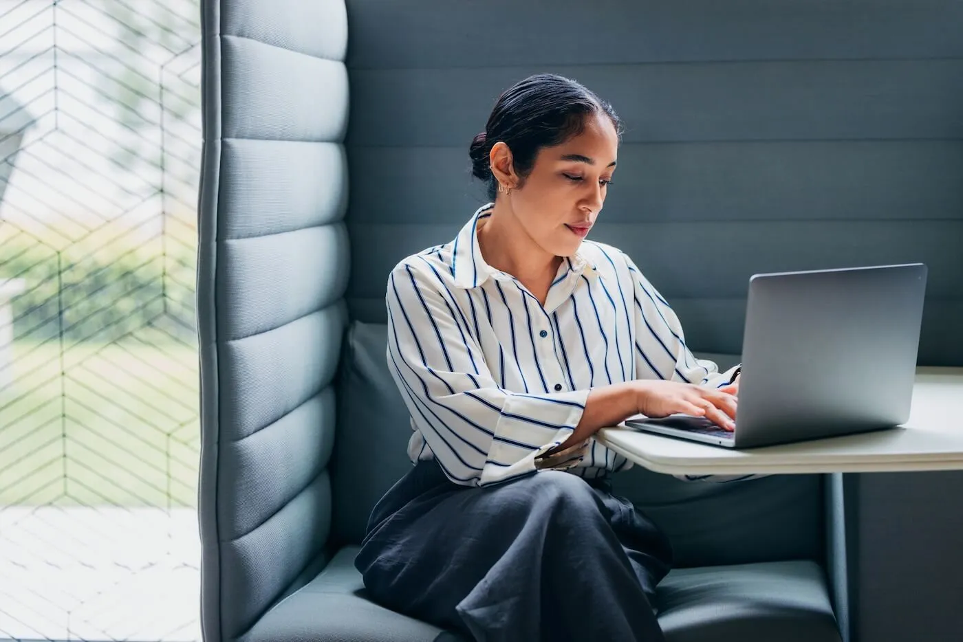 Focused businesswoman using her laptop in the office common area
