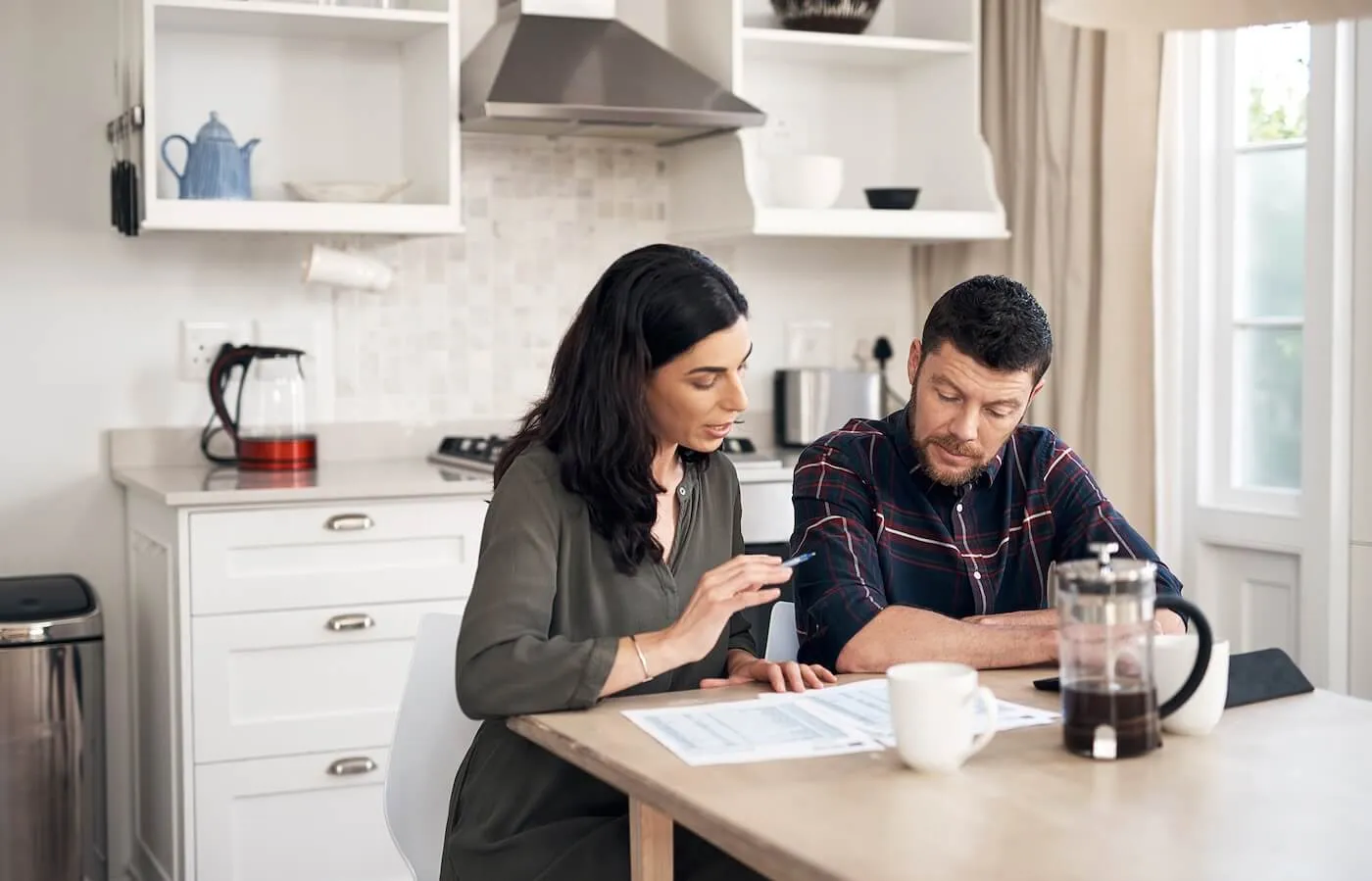 Focused couple discussing their finances in the kitchen