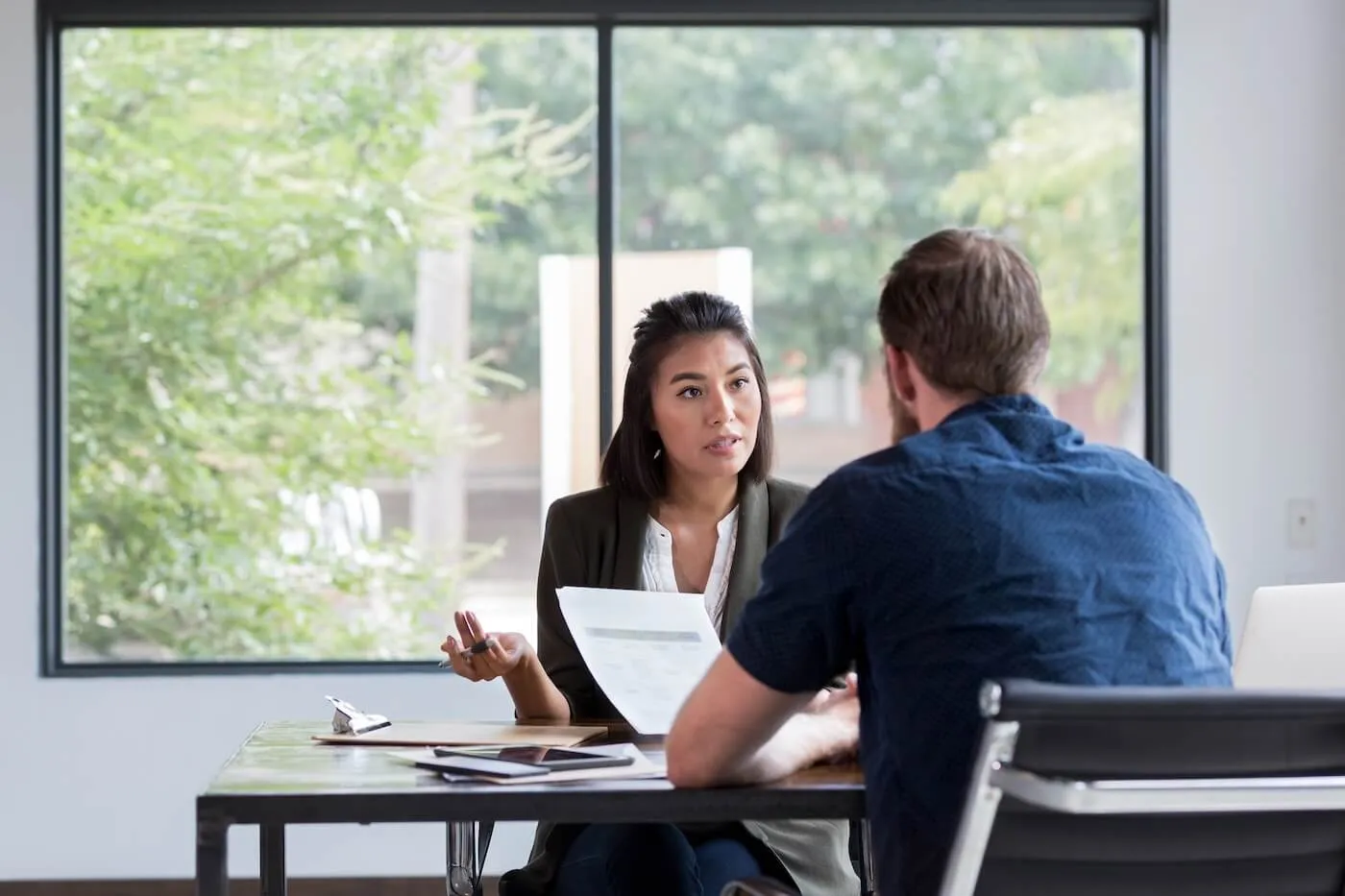 Female credit counselor explaining the terms to a male customer in her office