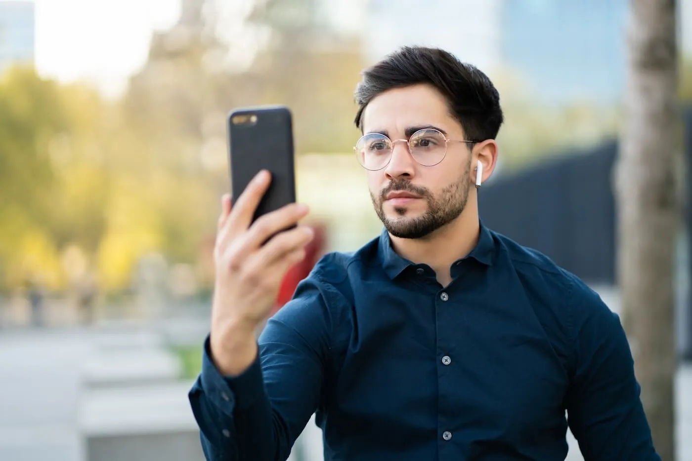 Young man using face id for unlock mobile phone outdoors