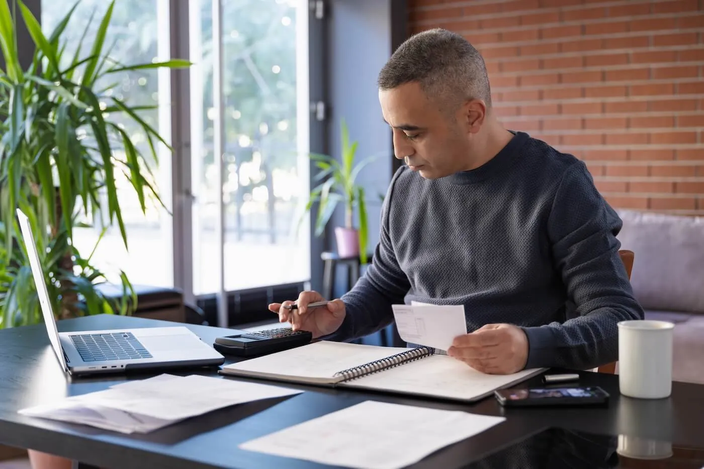 Focused mature man filing taxes in a home office