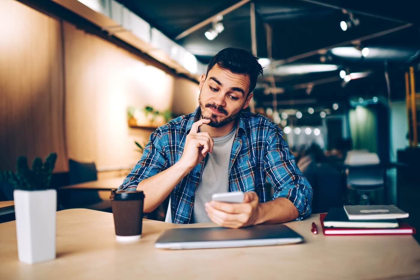 Concerned young man checking his smartphone in the cafe