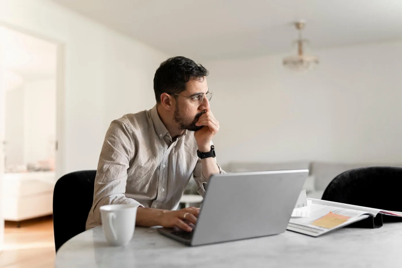 Pensive mature man using his laptop in a home office