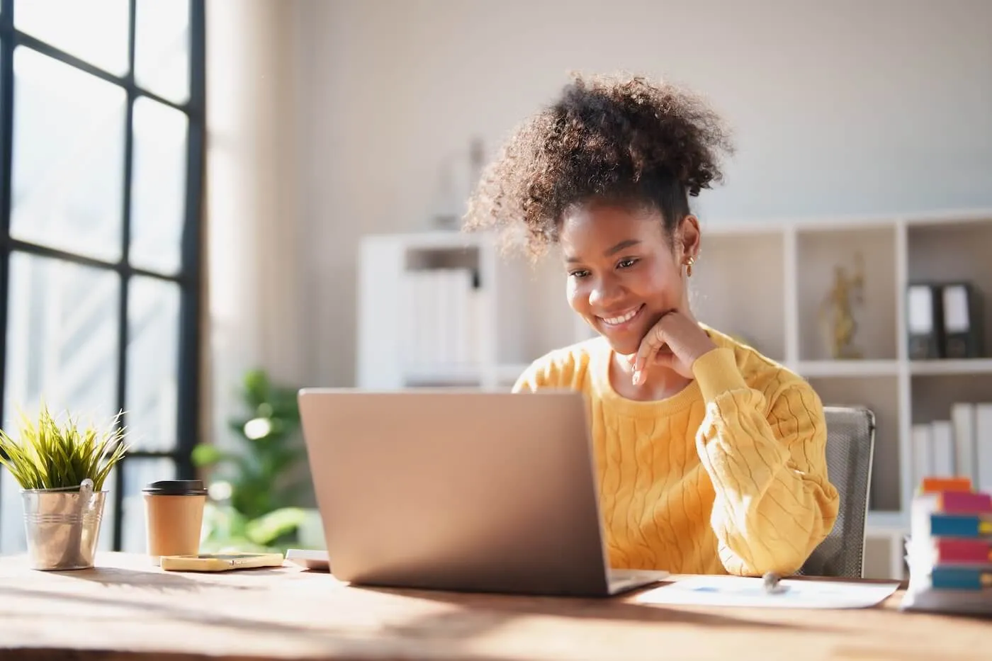 Smiling woman using her laptop at home