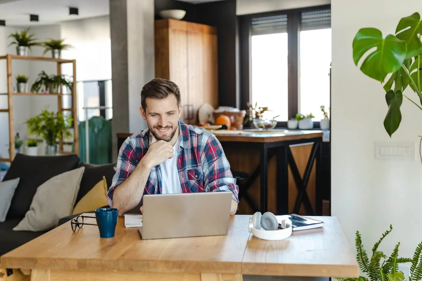 Smiling young man working on a laptop at home