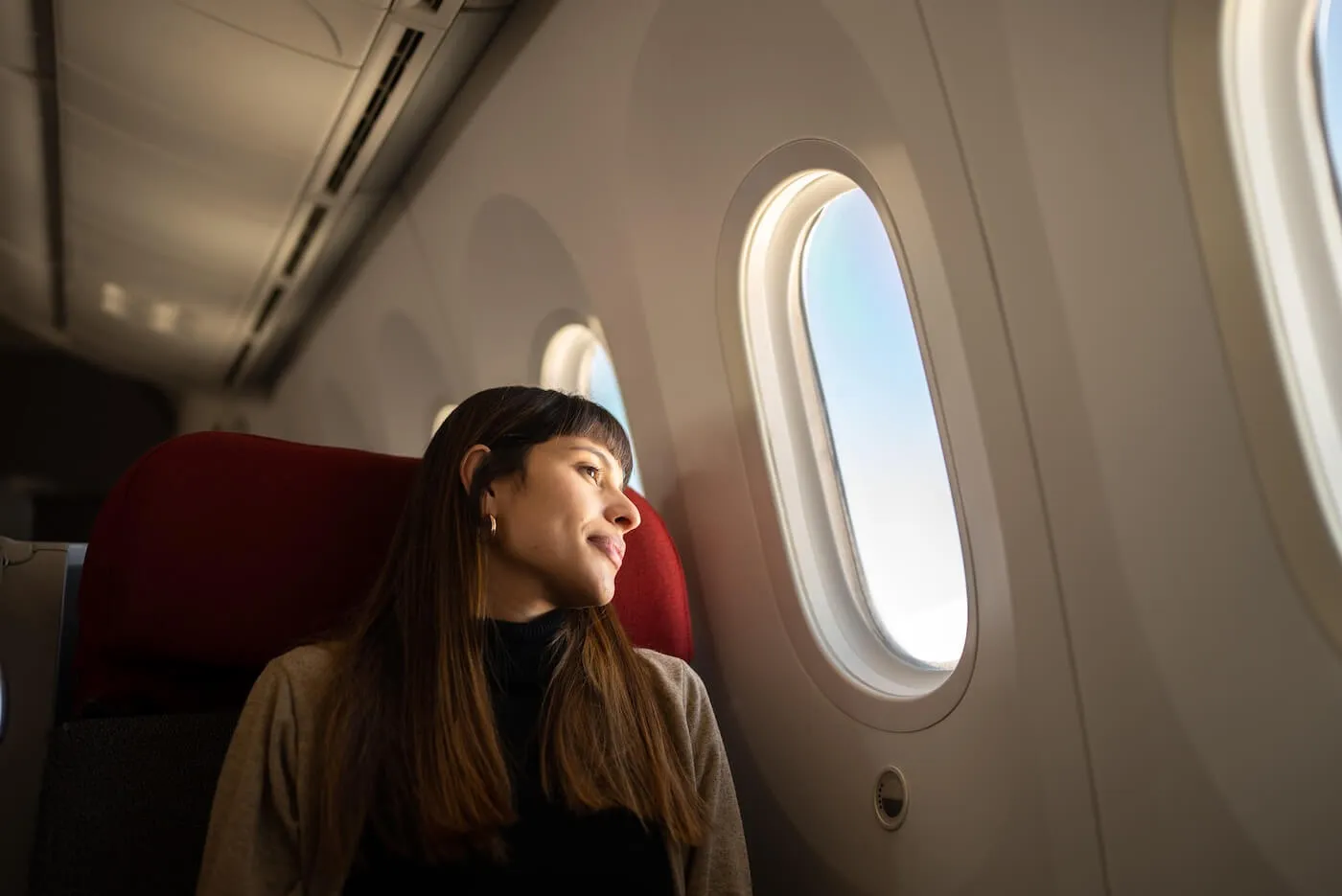 Pensive woman looking at the airplane window