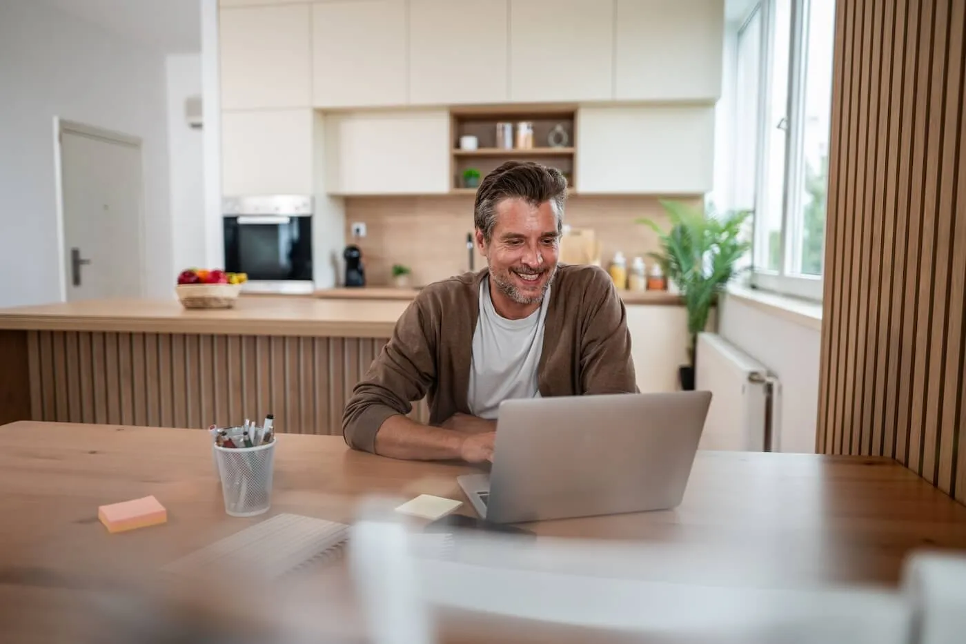 Smiling mature man using his laptop at home