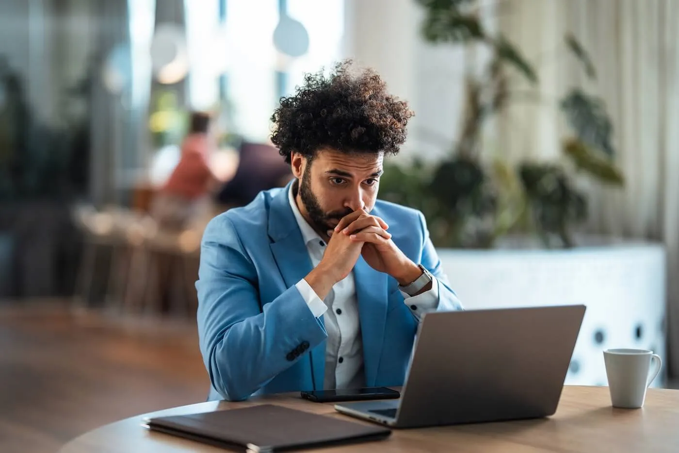 Concerned businessman using his laptop in the cafe