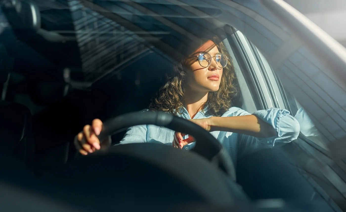 Pensive woman looking out the side window while standing in traffic.