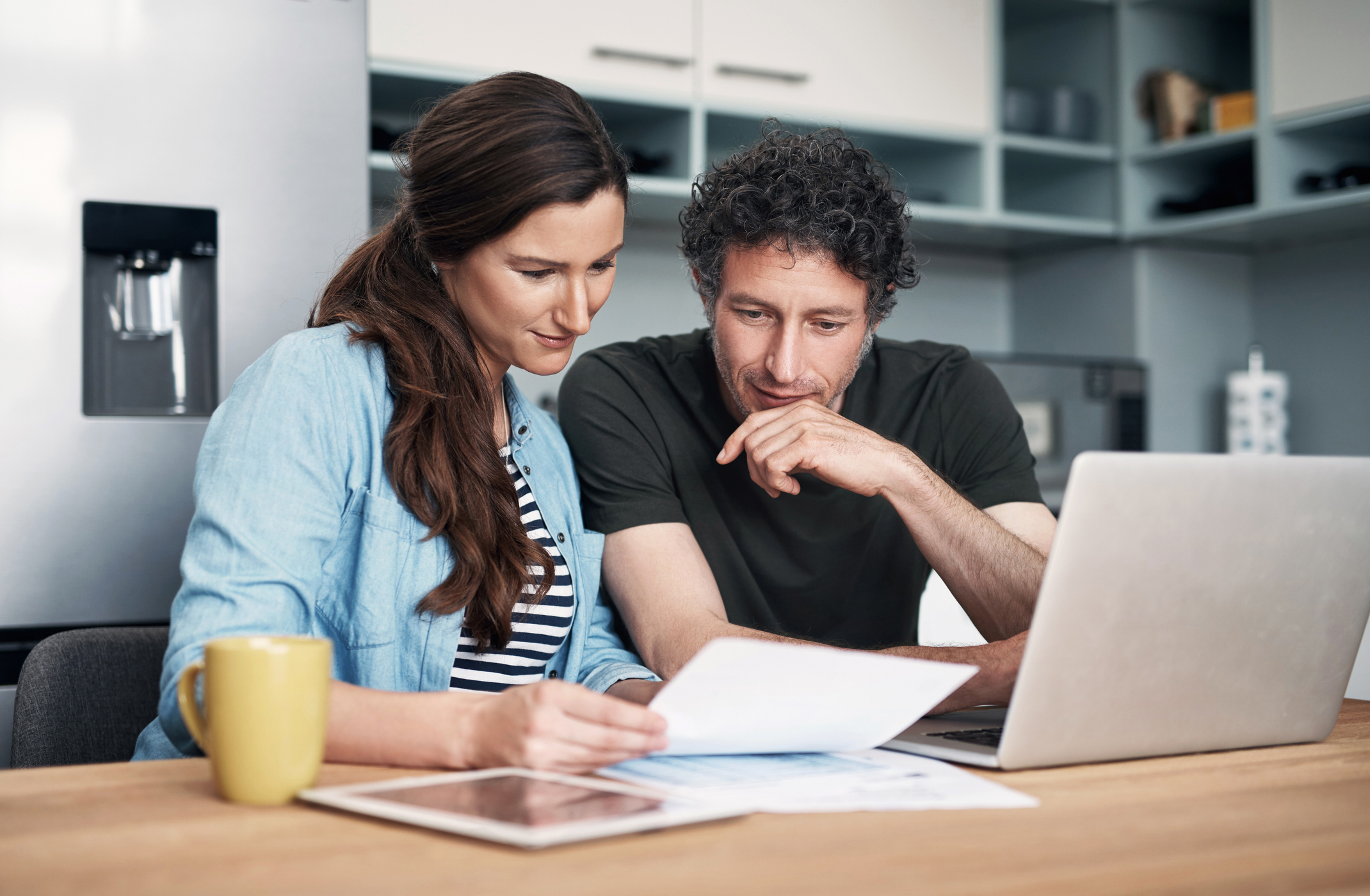 Couple filing taxes online in the kitchen