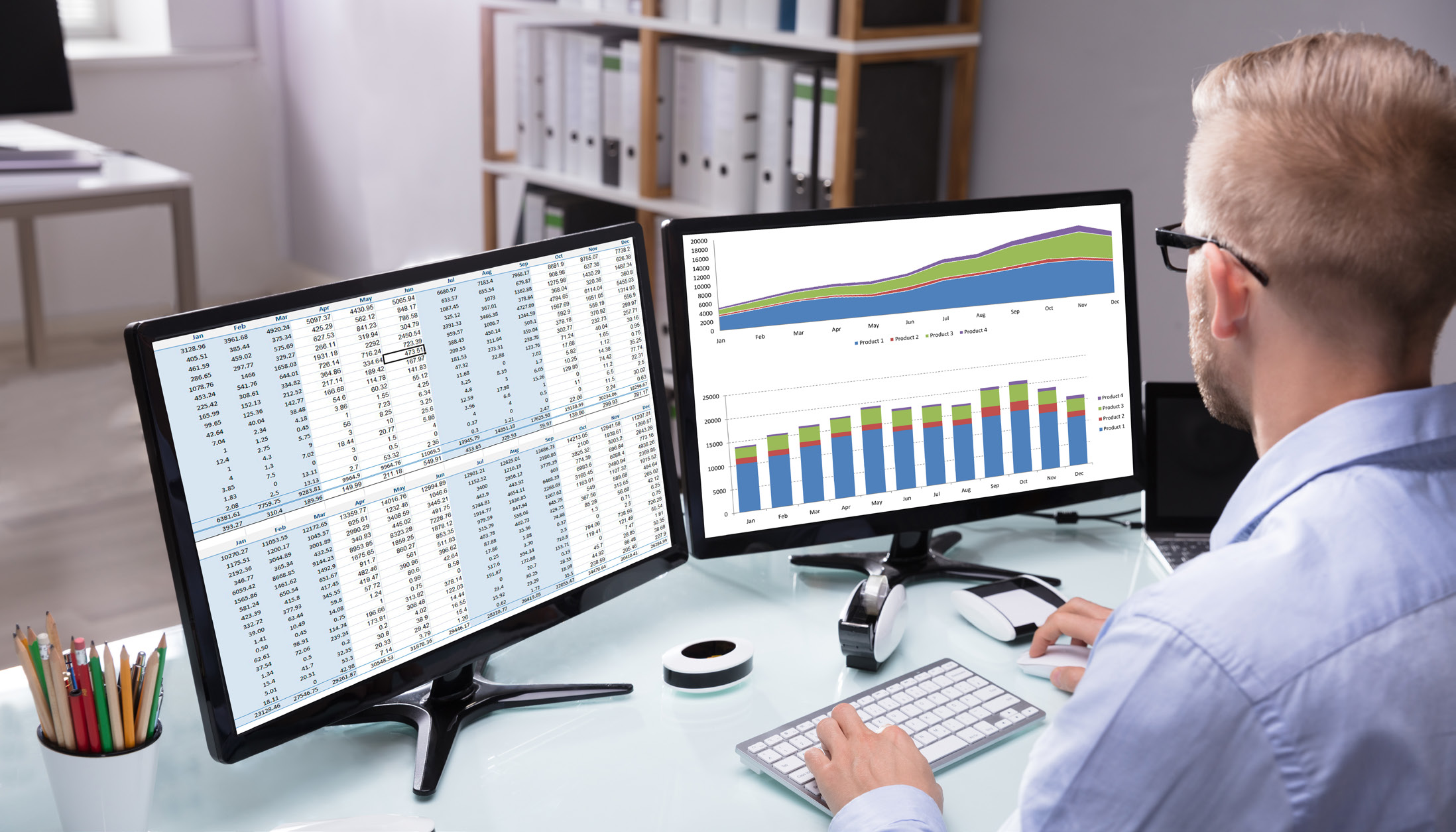 A man looking at two screens containing data - automating credit decisions.