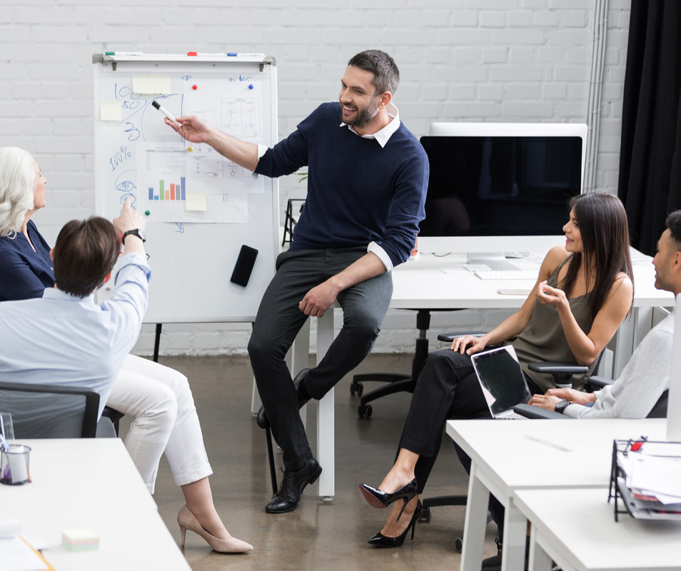 Man speaking to group pointing at whiteboard - automating credit decisions.