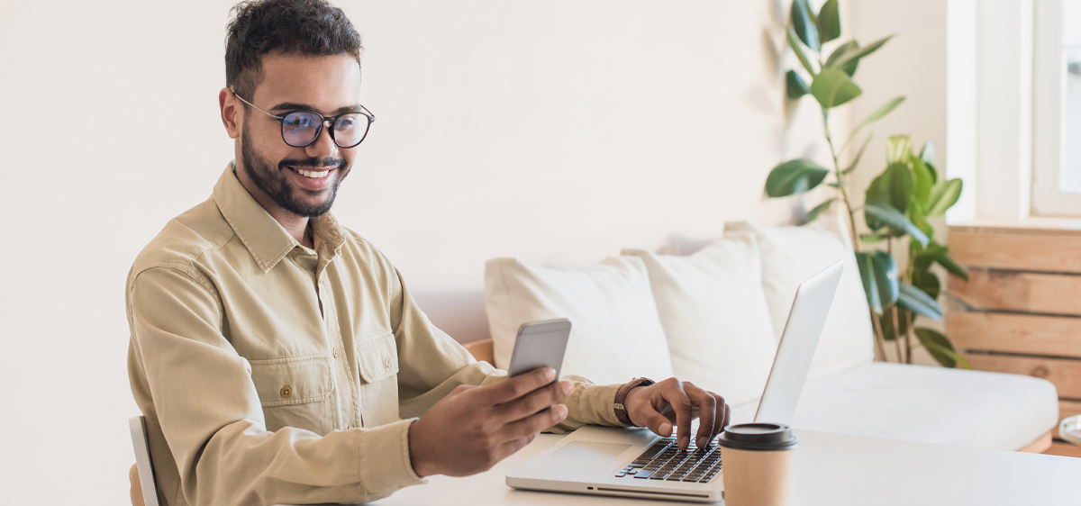 man on laptop and smart phone