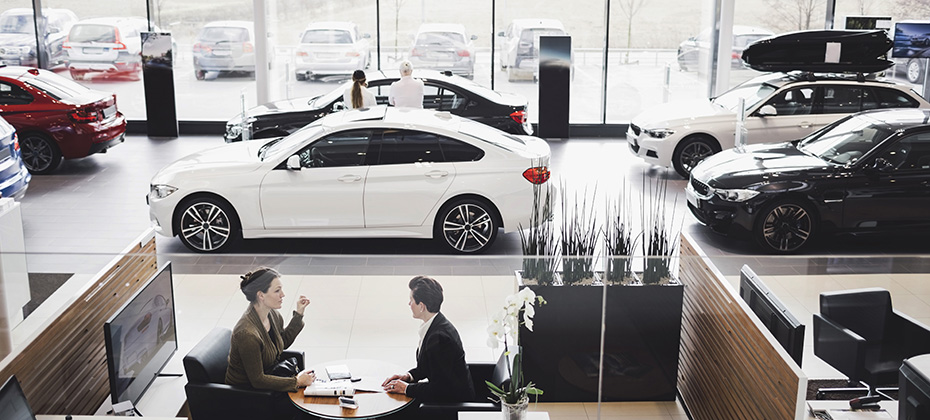 Automotive sales floor with customers looking at vehicles 