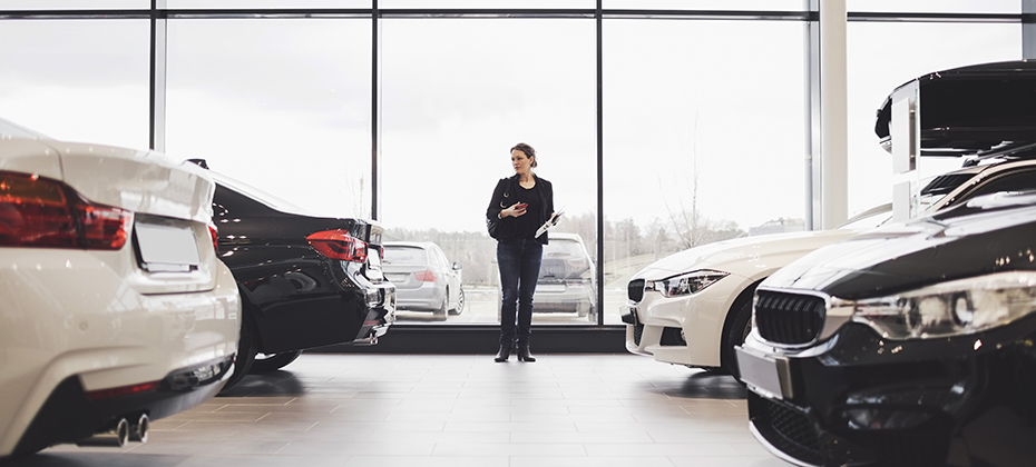 Woman looking at cars in auto dealership