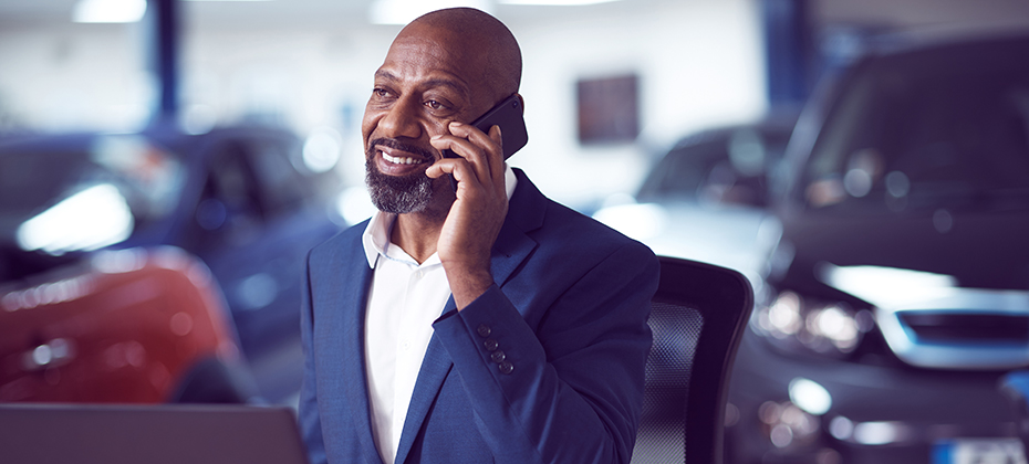 man in car dealership talking on phone