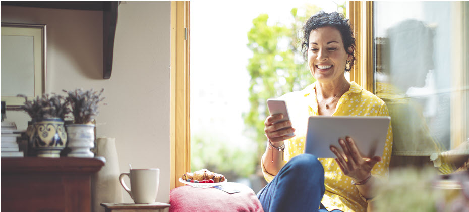 Woman looking at tablet and phone