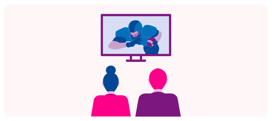 Two people watching a football game on a television screen