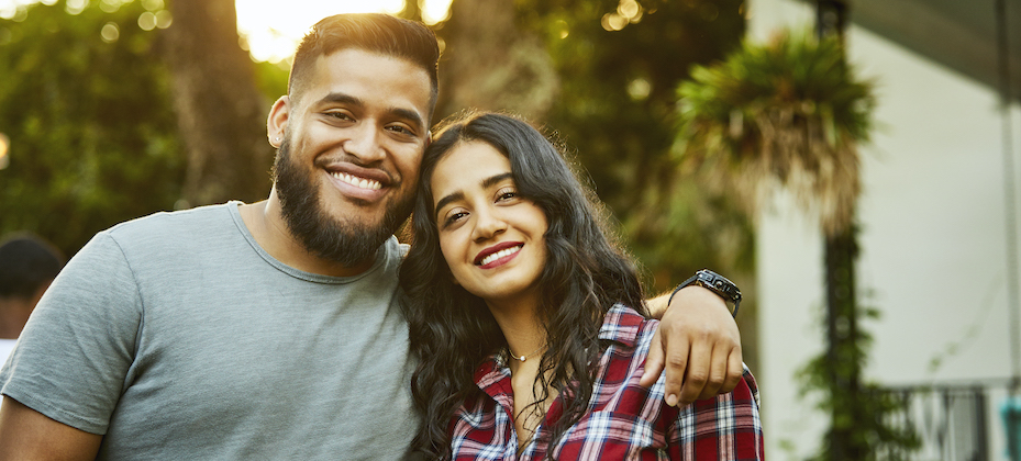 Latinx smiling friends. Young males and females are wearing casuals. They are in back yard.