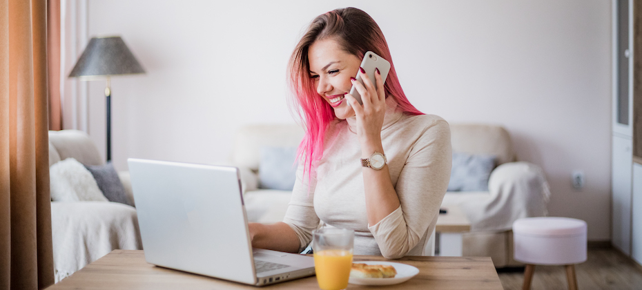 Young woman with pink hair in her apartment working.