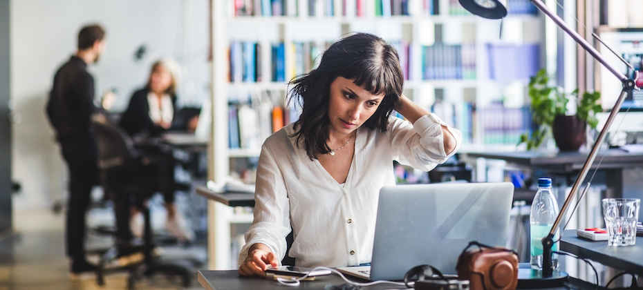 Businesswoman looking at laptop while sitting in office