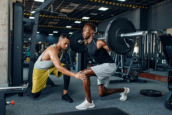 Weightlifter being coached by his trainer.