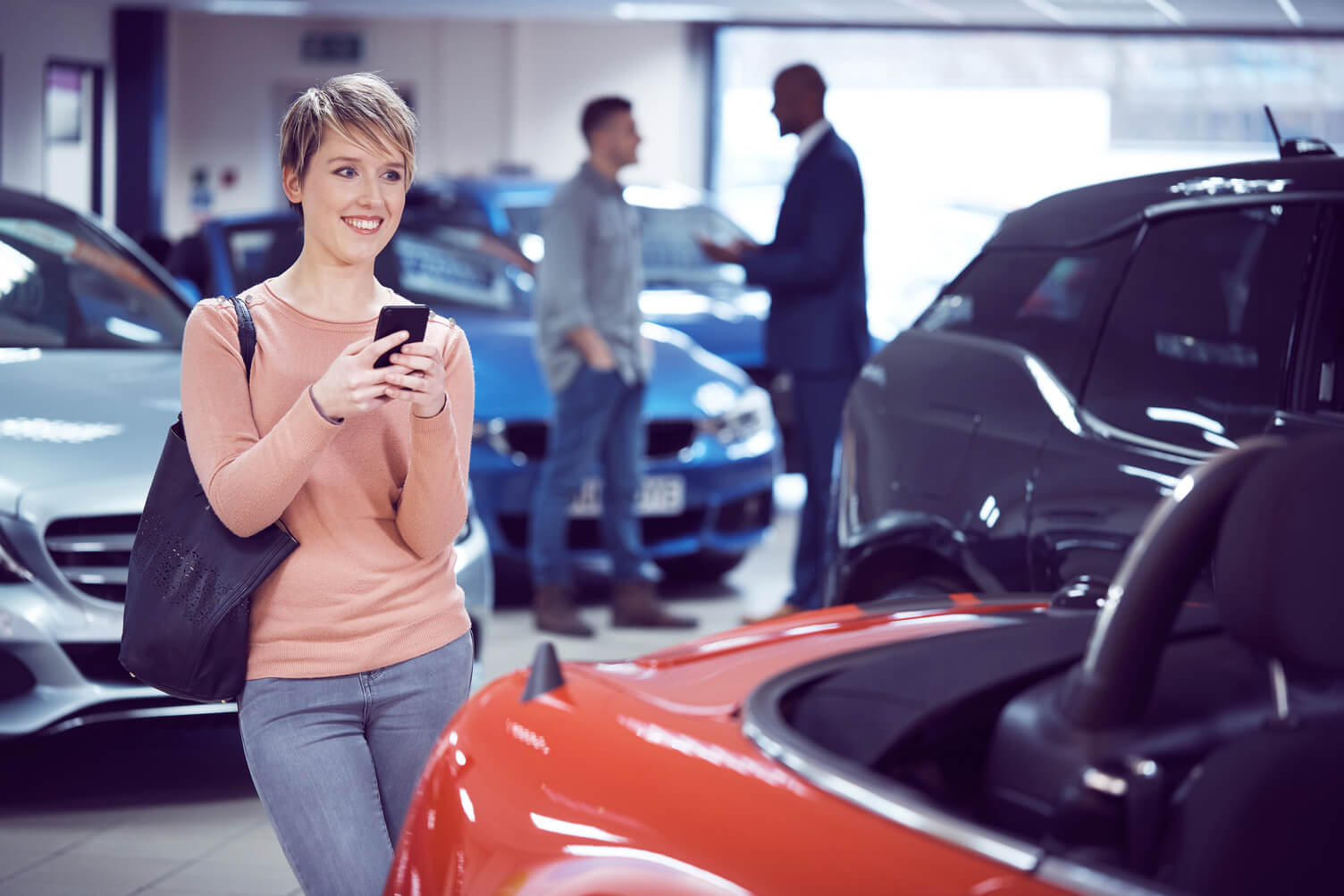 Woman smiling while in a dealership showroom.
