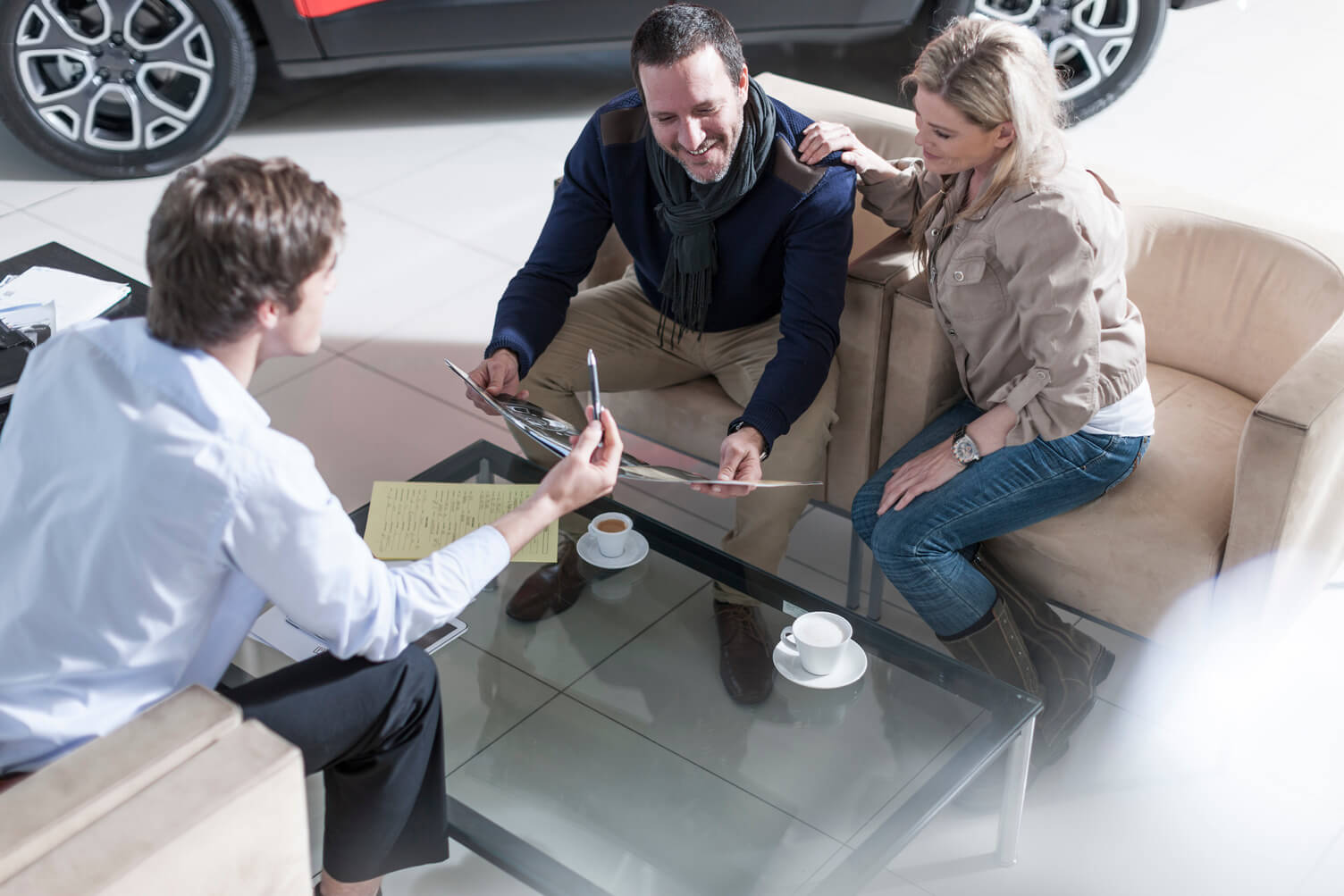 family looksing at tablet at car dealership