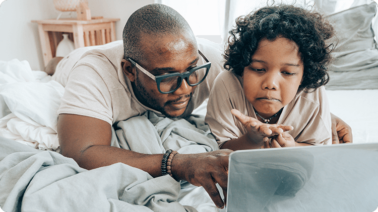 father and child looking at laptop