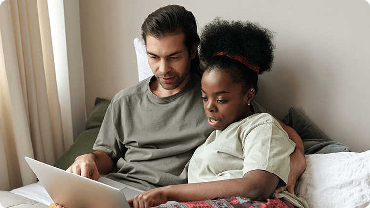 two people pointing at a laptop