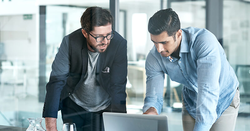 co workers discussing ideas over laptop