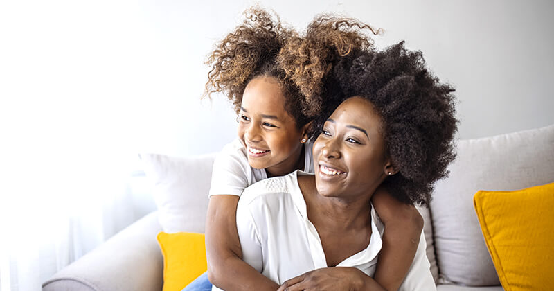 Mother and daughter smiling at home