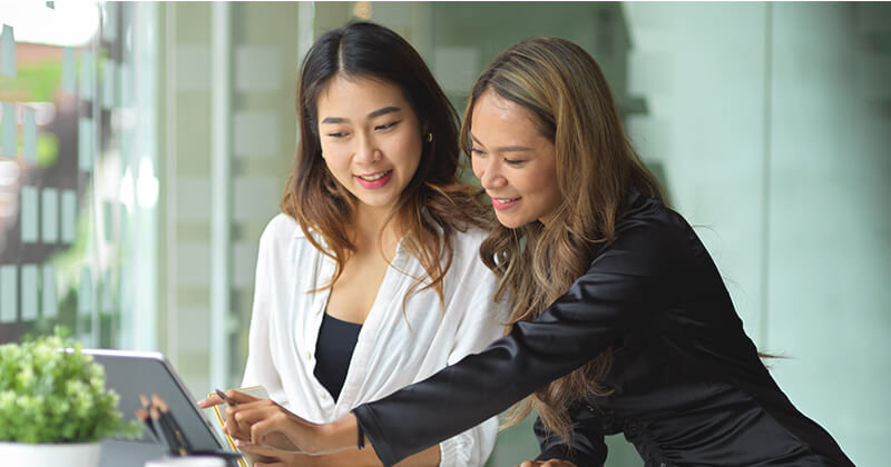 two women looking at a tablet