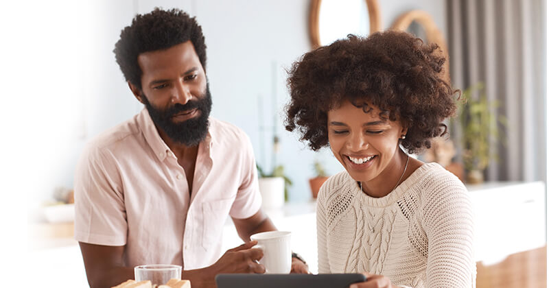 Couple using tablet at home