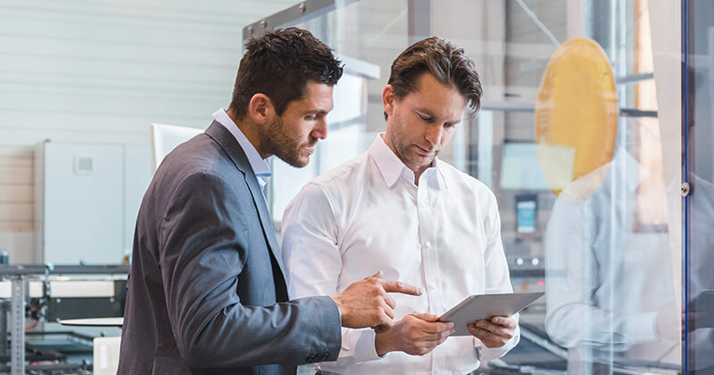 Two businessmen talking in factory