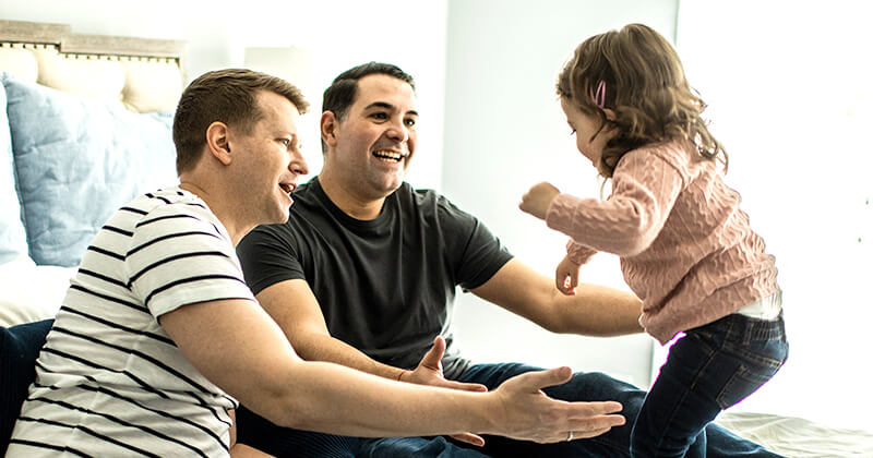 couple smiling with daughter in home