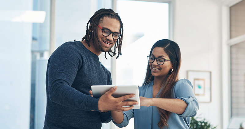 man and woman looking at tablet