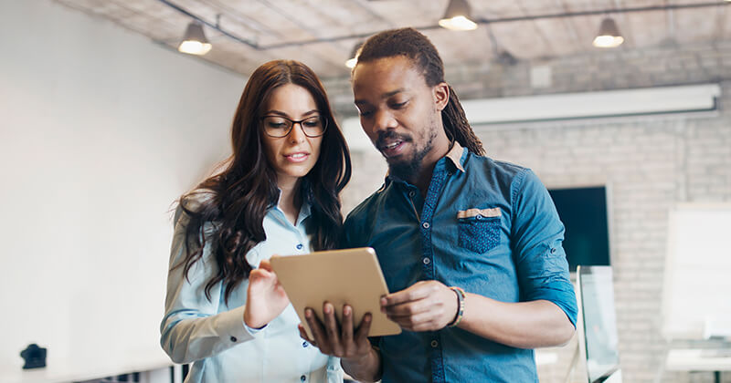 man and woman looking at tablet