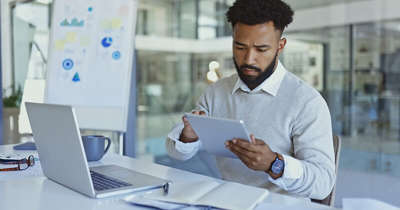 man working on laptop and tablet