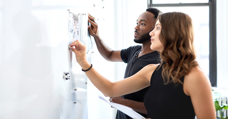 business colleagues looking at knowledge-based authentication questions on bulletin board