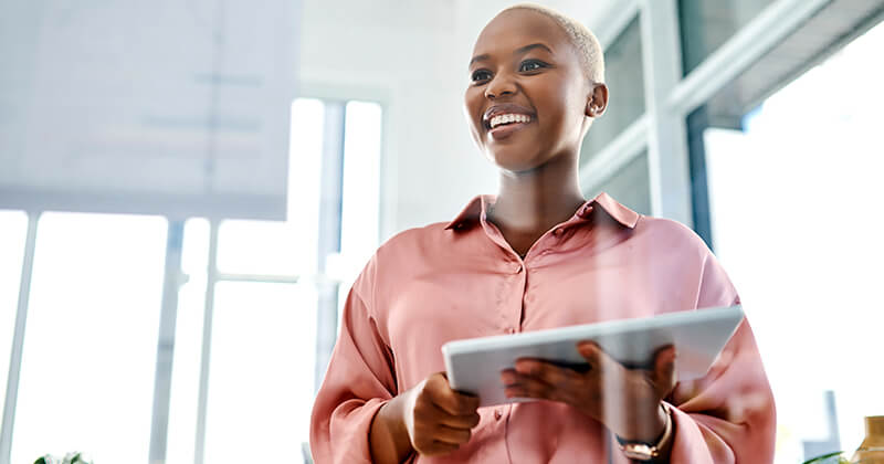 Woman smiling holding tablet in office
