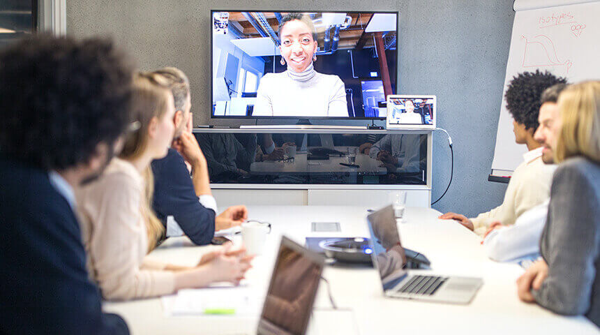Business team sitting around table in video meeting