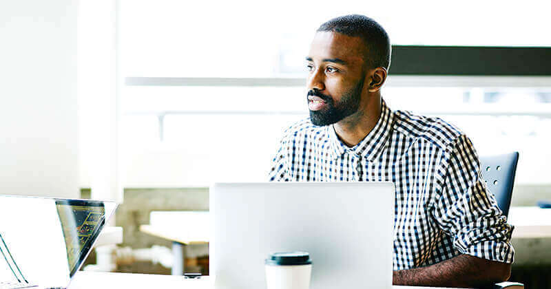 Businessman using laptop at workstation