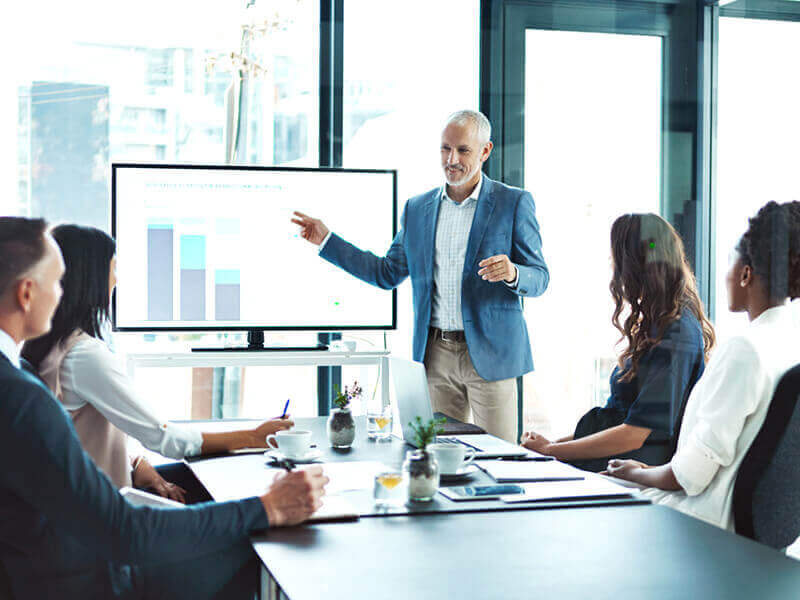 Businessperson standing and pointing giving presentation