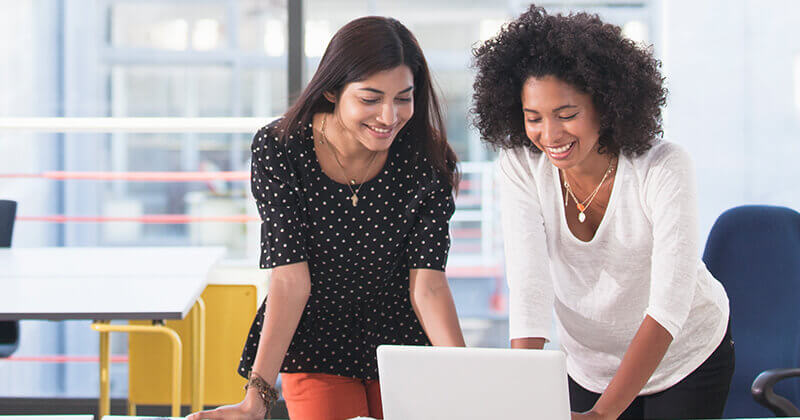 Businesswomen using laptop in modern office