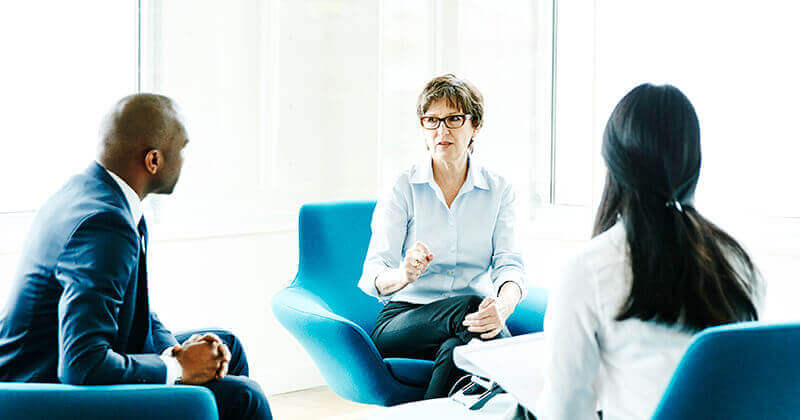 three colleagues meeting on chairs