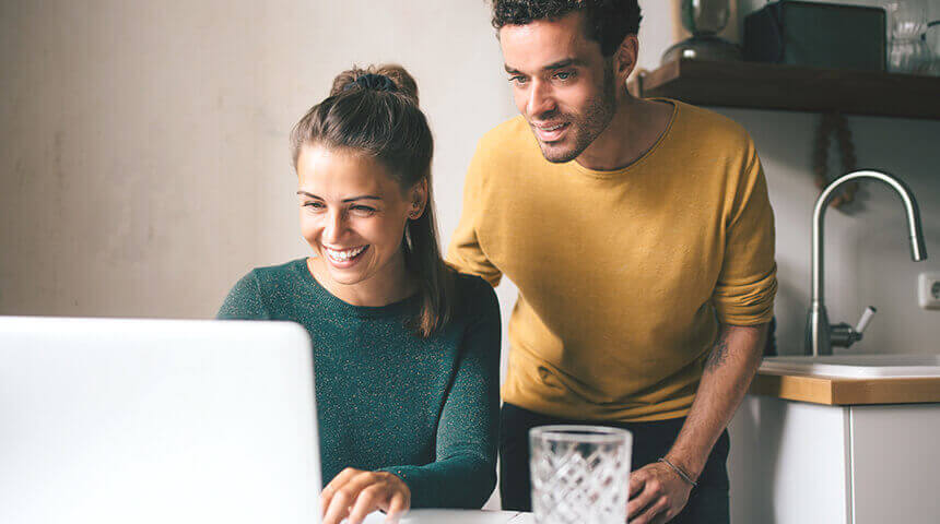 Couple smiling looking at laptop