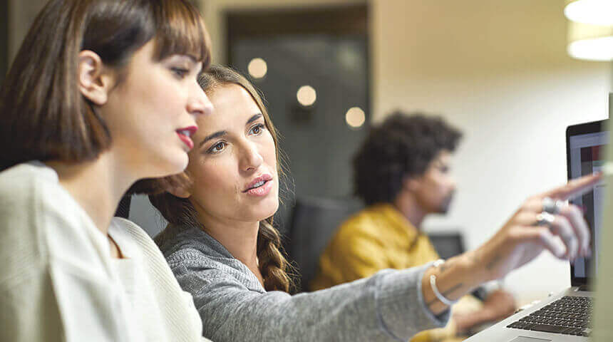 coworkers discussing over computer