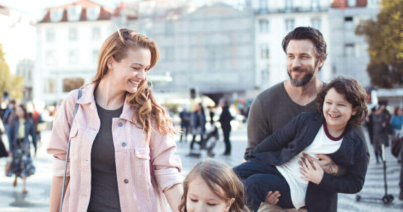 Family smiling in a city